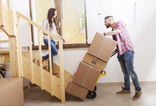Movers navigating stairs in an Enfield flat removal job